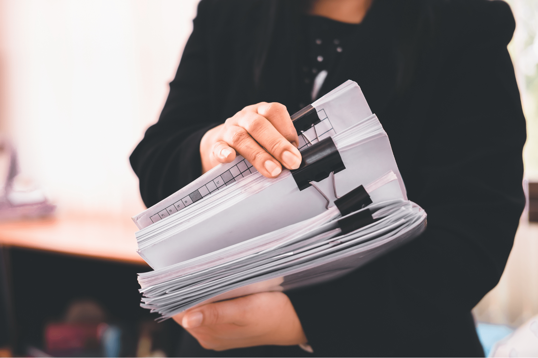 a business woman holding files and adhering to her company's document retention policy