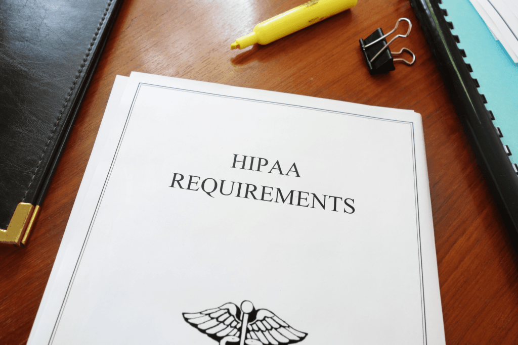 HIPAA Rules and Requirements binder on an employers desk