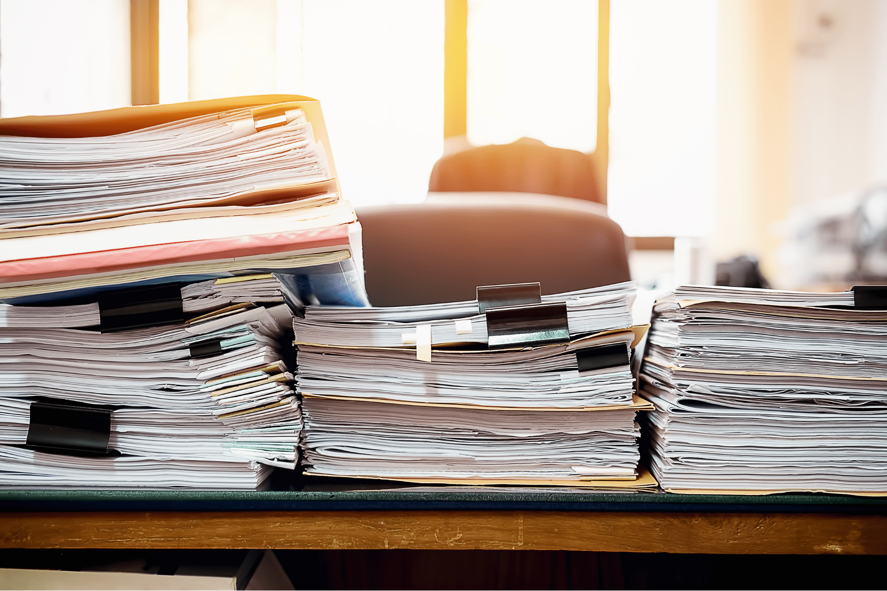 a stack of business documents on a desk illustrating the need for valuable papers insurance